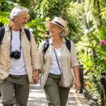 Pareja senior disfrutando de un viaje accesible y seguro en un entorno turístico natural.